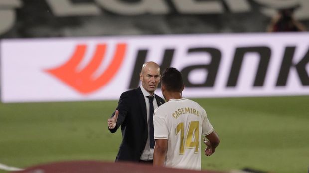 Real Madrid's head coach Zinedine Zidane, talks to his player Casemiro after he was substituted, during the Spanish La Liga soccer match between Real Madrid and Deportivo Alaves at the Alfredo di Stefano stadium in Madrid, Spain, Friday, July 10, 2020. (AP Photo/Bernat Armangue)