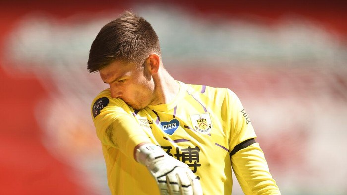 Burnleys goalkeeper Nick Pope wipes his face with his sleeve during the English Premier League soccer match between Liverpool and Burnley at Anfield, Liverpool, England, Saturday, July 11, 2020. (Oli Scarff/ Pool via AP)