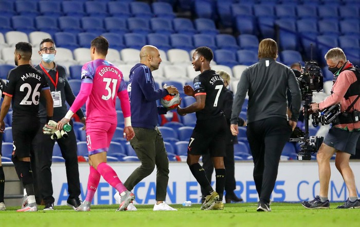 BRIGHTON, ENGLAND - JULY 11: Pep Guardiola, Manager of Manchester City interacts with Raheem Sterling of Manchester City as they celebrate victory following the Premier League match between Brighton & Hove Albion and Manchester City at American Express Community Stadium on July 11, 2020 in Brighton, England. Football Stadiums around Europe remain empty due to the Coronavirus Pandemic as Government social distancing laws prohibit fans inside venues resulting in all fixtures being played behind closed doors. (Photo by Julian Finney/Getty Images)