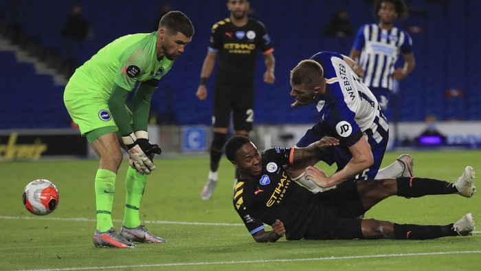 Manchester Citys Raheem Sterling, bottom scores his sides fifth goal during the English Premier League soccer match between Brighton and Manchester City at the Falmer stadium in Brighton, England, Saturday, July 11, 2020. (Adam Davy/Pool via AP)