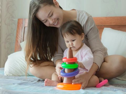 Beautiful toddler child girl playing with toys on the carpet