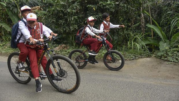 Sejumlah siswa SD mengayuh sepedanya saat pulang dari sekolahnya di Desa Bukit Tinggi, Kecamatan Gunungsari, Lombok Barat, NTB, Senin (13/7/2020). Pada hari pertama masuk sekolah di sebagian besar satuan pendidikan di wilayah NTB belum melaksanakan Kegiatan Belajar Mengajar (KBM) tatap muka dan masih dilakukan dari rumah secara daring atau bentuk lain memanfaatkan segala sumber daya yang dimiliki secara optimal karena kasus COVID-19 di NTB masih tinggi. ANTARA FOTO/Ahmad Subaidi/wsj.