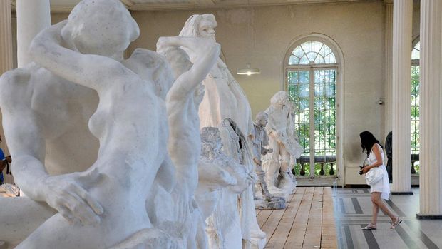 A woman prepares to take a picture, on August 4, 2013, of castings by French sculptor Auguste Rodin (1840-1917) displayed in his studio, close to his house, the 