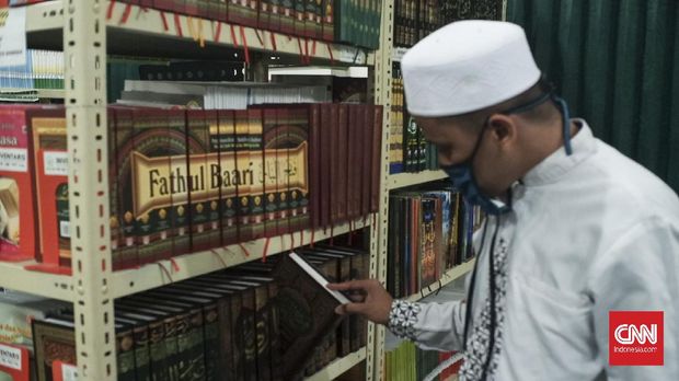 Wisuda Virtual Sekolah Madrasah The A-Team bekerja melakukan penyuntingan rekaman audio-visual di perpustakaan sekolah.