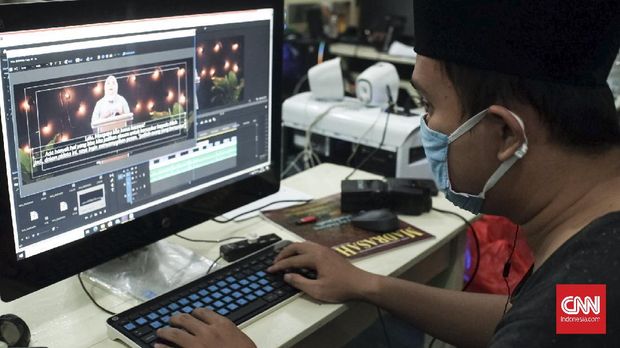 Wisuda Virtual Sekolah Madrasah The A-Team bekerja melakukan penyuntingan rekaman audio-visual di perpustakaan sekolah.