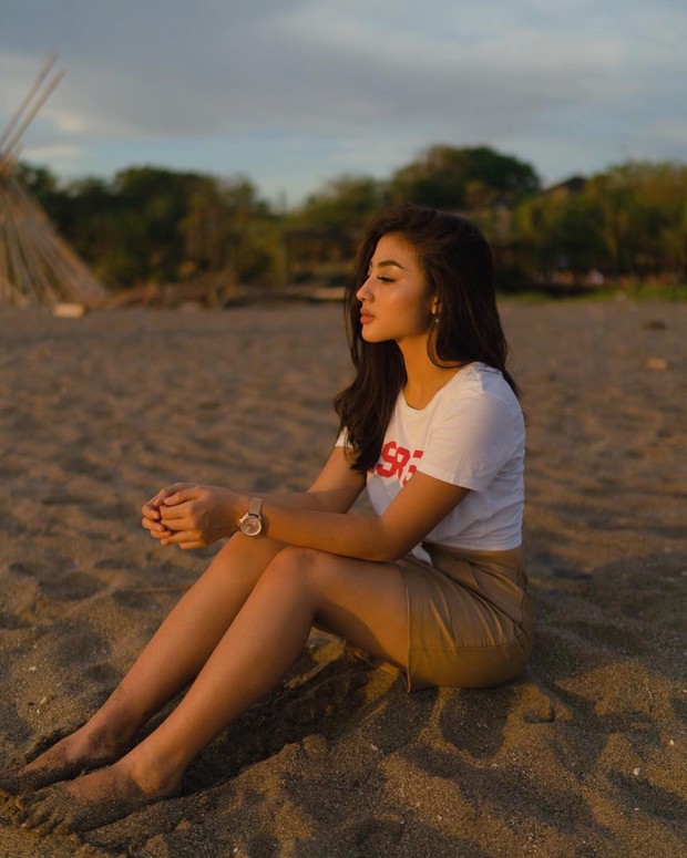 Duduk di hamparan pasir serta aksen sinar matahari yang cantik membuat pesona Margin Wieheerm semakin terpancar