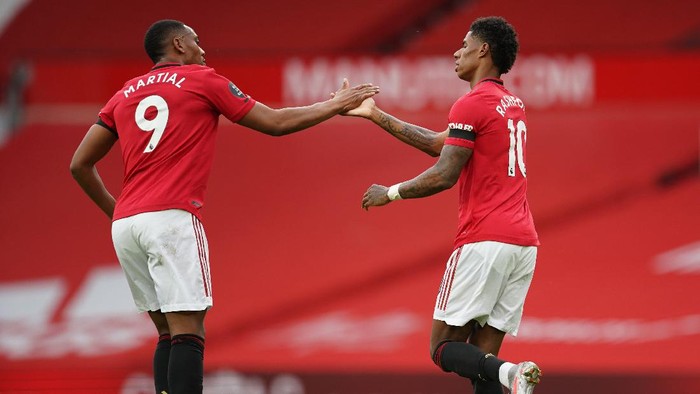 MANCHESTER, ENGLAND - JULY 13: Marcus Rashford of Manchester United celebrates with teammate Anthony Martial of Manchester United after scoring his teams first goal during the Premier League match between Manchester United and Southampton FC at Old Trafford on July 13, 2020 in Manchester, England. Football Stadiums around Europe remain empty due to the Coronavirus Pandemic as Government social distancing laws prohibit fans inside venues resulting in all fixtures being played behind closed doors. (Photo by Dave Thompson/Pool via Getty Images)