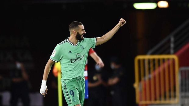 Real Madrid's Karim Benzema celebrates after scoring his side's second goal during the Spanish La Liga soccer match between Granada and Real Madrid at the Los Carmenes stadium in Granada, Spain, Monday, July 13, 2020. (AP Photo/Jose Breton)