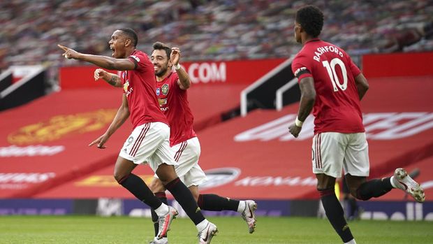 Manchester United's Anthony Martial, left, celebrates after scoring his ream's second goal during the English Premier League soccer match between Manchester United and Southampton at Old Trafford in Manchester, England, Monday, July 13, 2020. (AP Photo/Dave Thompson,Pool)