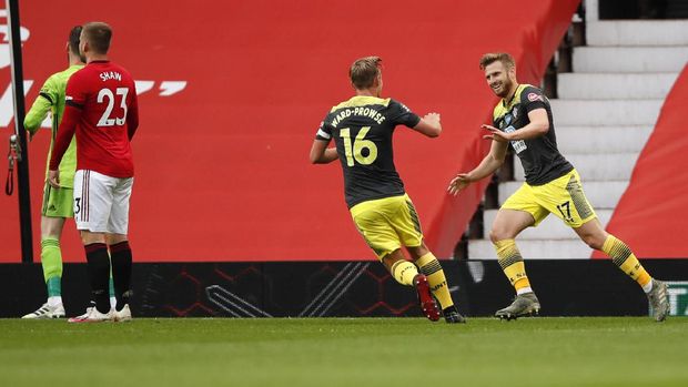 Southampton's Stuart Armstrong, right, is congratulated by teammate James Ward-Prowse after scoring his team's first goal during the English Premier League soccer match between Manchester United and Southampton at Old Trafford in Manchester, England, Monday, July 13, 2020. (AP Photo/Peter Powell,Pool)