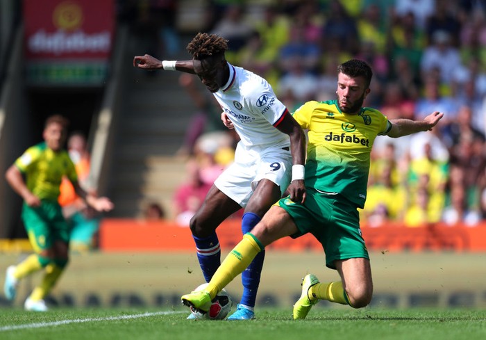 NORWICH, ENGLAND - AUGUST 24: Grant Hanley of Norwich City battles for possession with Tammy Abraham of Chelsea during the Premier League match between Norwich City and Chelsea FC at Carrow Road on August 24, 2019 in Norwich, United Kingdom. (Photo by Catherine Ivill/Getty Images)