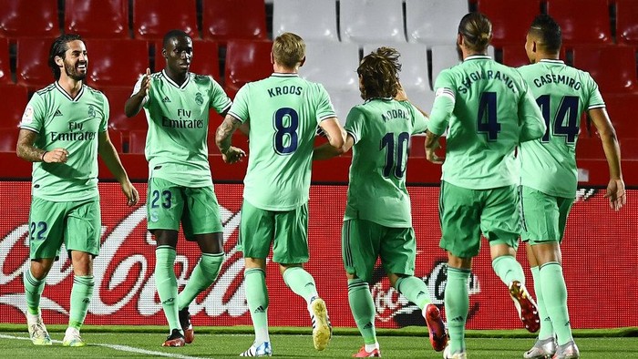 Real Madrids Ferland Mendy, second left, celebrates after scoring with teammates the opening goal during the Spanish La Liga soccer match between Granada and Real Madrid at the Los Carmenes stadium in Granada, Spain, Monday, July 13, 2020. (AP Photo/Jose Breton)