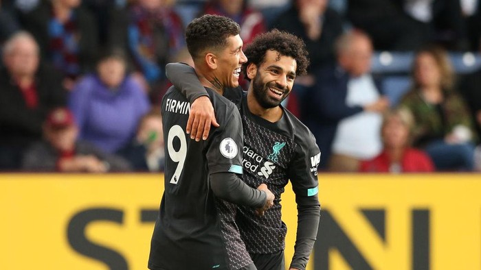 BURNLEY, ENGLAND - AUGUST 31: Roberto Firmino of Liverpool celebrates with teammate Mohamed Salah after scoring his teams third goal  during the Premier League match between Burnley FC and Liverpool FC at Turf Moor on August 31, 2019 in Burnley, United Kingdom. (Photo by Jan Kruger/Getty Images)