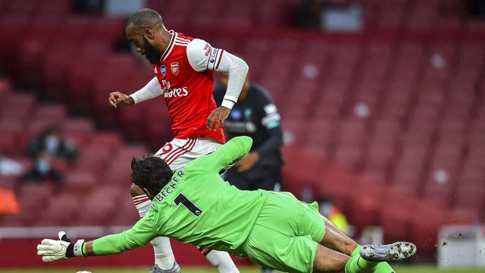 Alisson Becker Arsenals Alexandre Lacazette runs past Liverpools goalkeeper Alisson before scoring his team first goal during the English Premier League soccer match between Arsenal and Liverpool at the Emirates Stadium in London, England, Wednesday, July 15, 2020. (Glyn Kirk/Pool via AP)