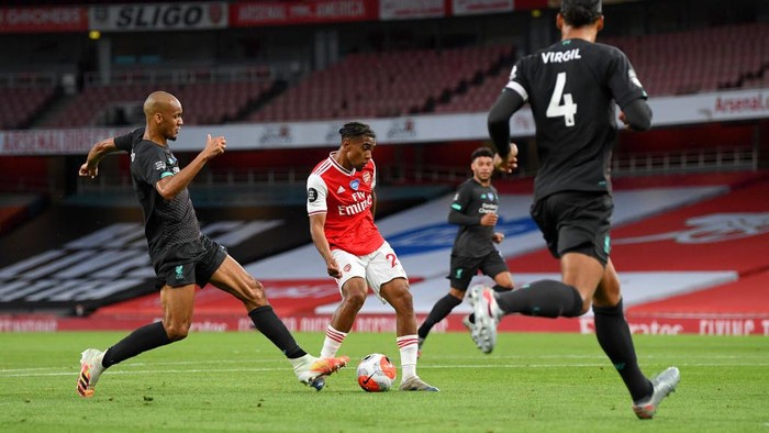 LONDON, ENGLAND - JULY 15: Reiss Nelson of Arsenal scores his sides second goal during the Premier League match between Arsenal FC and Liverpool FC at Emirates Stadium on July 15, 2020 in London, England. Football Stadiums around Europe remain empty due to the Coronavirus Pandemic as Government social distancing laws prohibit fans inside venues resulting in all fixtures being played behind closed doors. (Photo by Shaun Botterill/Getty Images)