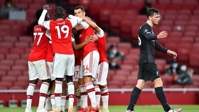 LONDON, ENGLAND - JULY 15: Reiss Nelson of Arsenal celebrates with teammates after scoring his sides second goal during the Premier League match between Arsenal FC and Liverpool FC at Emirates Stadium on July 15, 2020 in London, England. Football Stadiums around Europe remain empty due to the Coronavirus Pandemic as Government social distancing laws prohibit fans inside venues resulting in all fixtures being played behind closed doors. (Photo by Glyn Kirk/Pool via Getty Images)