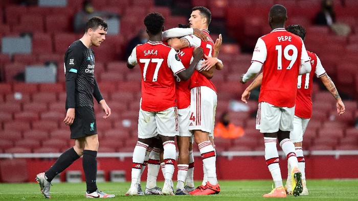 LONDON, ENGLAND - JULY 15: Reiss Nelson of Arsenal celebrates with teammates after scoring his sides second goal during the Premier League match between Arsenal FC and Liverpool FC at Emirates Stadium on July 15, 2020 in London, England. Football Stadiums around Europe remain empty due to the Coronavirus Pandemic as Government social distancing laws prohibit fans inside venues resulting in all fixtures being played behind closed doors. (Photo by Glyn Kirk/Pool via Getty Images)