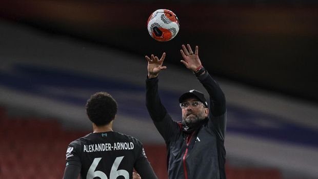 Liverpool's manager Jurgen Klopp passes the ball to Liverpool's Trent Alexander-Arnold during the English Premier League soccer match between Arsenal and Liverpool at the Emirates Stadium in London, England, Wednesday, July 15, 2020. (Shaun Botterill/Pool via AP)
