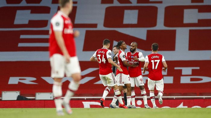 Arsenal LONDON, ENGLAND - JULY 15: Reiss Nelson of Arsenal celebrates with teammates after scoring his sides second goal during the Premier League match between Arsenal FC and Liverpool FC at Emirates Stadium on July 15, 2020 in London, England. Football Stadiums around Europe remain empty due to the Coronavirus Pandemic as Government social distancing laws prohibit fans inside venues resulting in all fixtures being played behind closed doors. (Photo by Paul Childs/Pool via Getty Images)