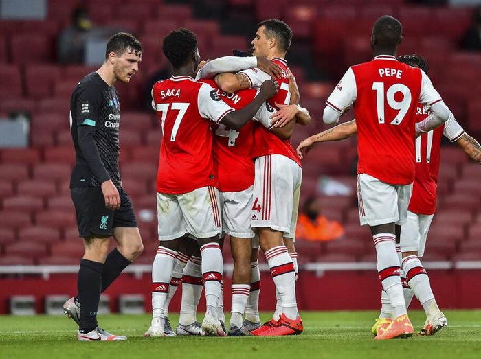 Arsenal players celebrate after scoring their second goal during the English Premier League soccer match between Arsenal and Liverpool at the Emirates Stadium in London, England, Wednesday, July 15, 2020. Glyn Kirk/Pool via AP)