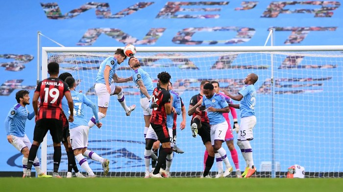 MANCHESTER, ENGLAND - JULY 15: John Stones and Nicolas Otamendi of Manchester City jump for the ball during the Premier League match between Manchester City and AFC Bournemouth  at Etihad Stadium on July 15, 2020 in Manchester, England. Football Stadiums around Europe remain empty due to the Coronavirus Pandemic as Government social distancing laws prohibit fans inside venues resulting in all fixtures being played behind closed doors. (Photo by Laurence Griffiths/Getty Images)