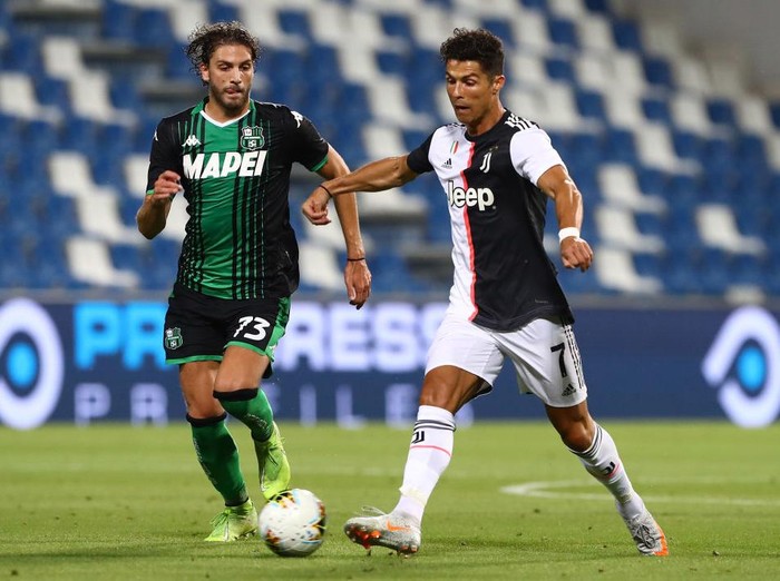 REGGIO NELLEMILIA, ITALY - JULY 15:  Cristiano Ronaldo (R) of Juventus FC is challenged by Manuel Locatelli (L) of US Sassuolo during the Serie A match between US Sassuolo and Juventus at Mapei Stadium - Citta del Tricolore on July 15, 2020 in Reggio nellEmilia, Italy.  (Photo by Marco Luzzani/Getty Images)