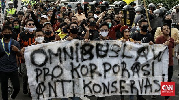 Kelompok buruh, petani, dan mahasiswa menolak Omnibus Law RUU Cipta Lapangan Kerja menggelar aksi di sisi kiri pintu gerbang DPR RI, Jakarta, Kamis (16/7). Pemerintah dan DPR dinilai gagal menangkap aspirasi masyarakat. CNN Indonesia/Andry Novelino