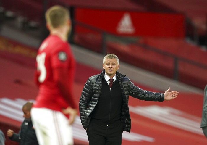 Manchester Uniteds manager Ole Gunnar Solskjaer gestures as he talks to Manchester Uniteds Luke Shaw during the English Premier League soccer match between Manchester United and Southampton at Old Trafford in Manchester, England, Monday, July 13, 2020. (AP Photo/Dave Thompson,Pool)