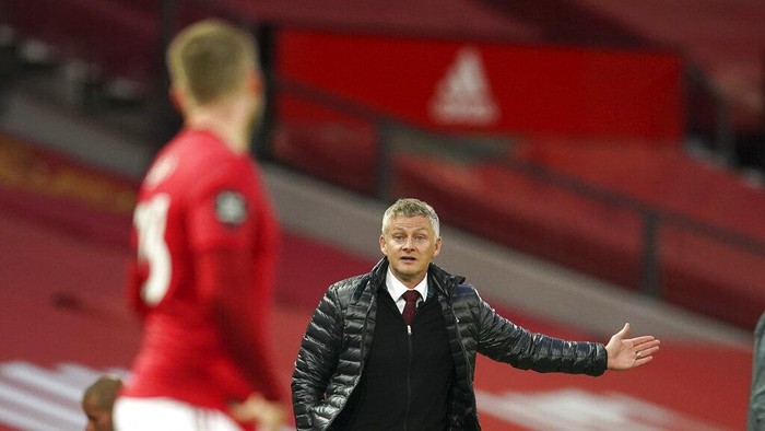 Manchester Uniteds manager Ole Gunnar Solskjaer gestures as he talks to Manchester Uniteds Luke Shaw during the English Premier League soccer match between Manchester United and Southampton at Old Trafford in Manchester, England, Monday, July 13, 2020. (AP Photo/Dave Thompson,Pool)