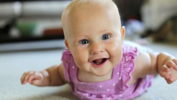 Baby reaching for colorful wooden blocks