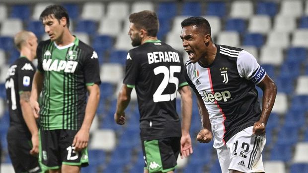 Juventus' Alex Sandro, right, celebrates after scoring a goal during a Serie A soccer match between Sassuolo and Juventus at the Mapei Stadium in Reggio Emilia, Italy, Wednesday, July 15, 2020. (Massimo Paolone/LaPresse via AP)