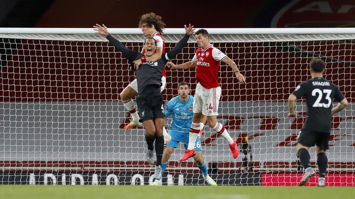 LONDON, ENGLAND - JULY 15: Virgil van Dijk of Liverpool jumps for the ball with David Luiz of Arsenal during the Premier League match between Arsenal FC and Liverpool FC at Emirates Stadium on July 15, 2020 in London, England. Football Stadiums around Europe remain empty due to the Coronavirus Pandemic as Government social distancing laws prohibit fans inside venues resulting in all fixtures being played behind closed doors. (Photo by Paul Childs/Pool via Getty Images)