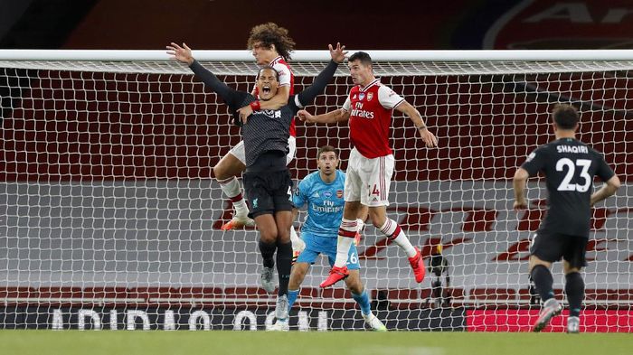 Virgil van Dijk vs Arsenal LONDON, ENGLAND - JULY 15: Virgil van Dijk of Liverpool jumps for the ball with David Luiz of Arsenal during the Premier League match between Arsenal FC and Liverpool FC at Emirates Stadium on July 15, 2020 in London, England. Football Stadiums around Europe remain empty due to the Coronavirus Pandemic as Government social distancing laws prohibit fans inside venues resulting in all fixtures being played behind closed doors. (Photo by Paul Childs/Pool via Getty Images)