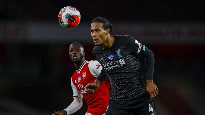 Liverpools Virgil van Dijk, right, duels for the ball with Arsenals Nicolas Pepe during the English Premier League soccer match between Arsenal and Liverpool at the Emirates Stadium in London, England, Wednesday, July 15, 2020. (Paul Childs/Pool via AP)