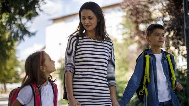 Mother and kids going home from school