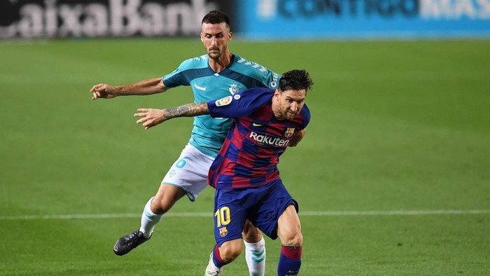 BARCELONA, SPAIN - JULY 16: Lionel Messi of FC Barcelona is challenged by Oier Sanjurjo of Osasuna during the Liga match between FC Barcelona and CA Osasuna at Camp Nou on July 16, 2020 in Barcelona, Spain. (Photo by David Ramos/Getty Images)