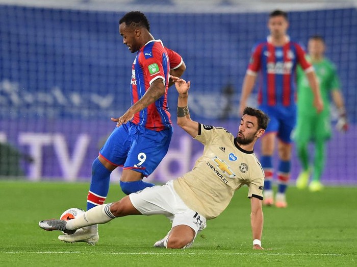 LONDON, ENGLAND - JULY 16: Bruno Fernandes of Manchester United and Jordan Ayew of Crystal Palace clash during the Premier League match between Crystal Palace and Manchester United at Selhurst Park on July 16, 2020 in London, England. Football Stadiums around Europe remain empty due to the Coronavirus Pandemic as Government social distancing laws prohibit fans inside venues resulting in all fixtures being played behind closed doors. (Photo by Glyn Kirk/Pool via Getty Images)