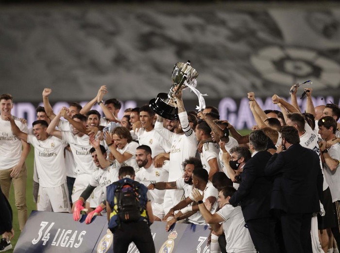 Real Madrid's head coach Zinedine Zidane, holds the trophy as he poses for the photographers after winning the Spanish La Liga 2019-2020 following a soccer match between Real Madrid and Villareal at the Alfredo di Stefano stadium in Madrid, Spain, Thursday, July 16, 2020. (AP Photo/Bernat Armangue)