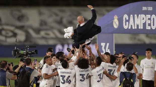 Real Madrid's head coach Zinedine Zidane, holds the trophy as he poses for the photographers after winning the Spanish La Liga 2019-2020 following a soccer match between Real Madrid and Villareal at the Alfredo di Stefano stadium in Madrid, Spain, Thursday, July 16, 2020. (AP Photo/Bernat Armangue)