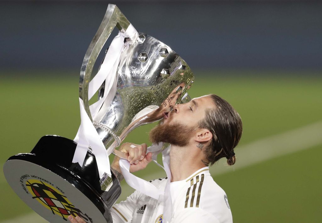 Real Madrid's head coach Zinedine Zidane, holds the trophy as he poses for the photographers after winning the Spanish La Liga 2019-2020 following a soccer match between Real Madrid and Villareal at the Alfredo di Stefano stadium in Madrid, Spain, Thursday, July 16, 2020. (AP Photo/Bernat Armangue)
