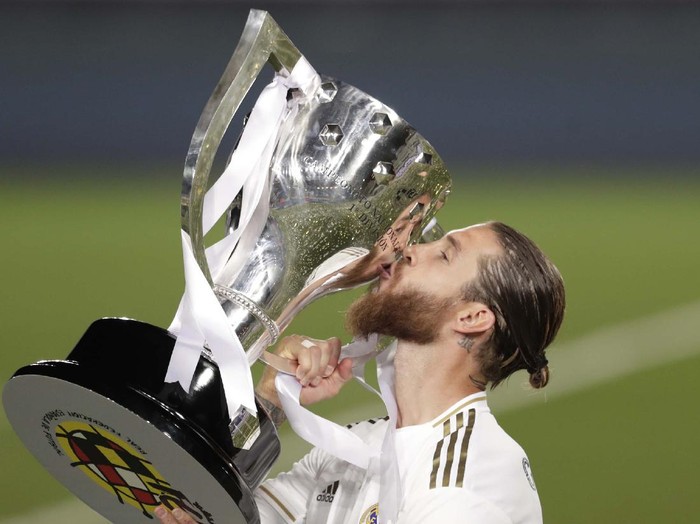 Real Madrid's head coach Zinedine Zidane, holds the trophy as he poses for the photographers after winning the Spanish La Liga 2019-2020 following a soccer match between Real Madrid and Villareal at the Alfredo di Stefano stadium in Madrid, Spain, Thursday, July 16, 2020. (AP Photo/Bernat Armangue)