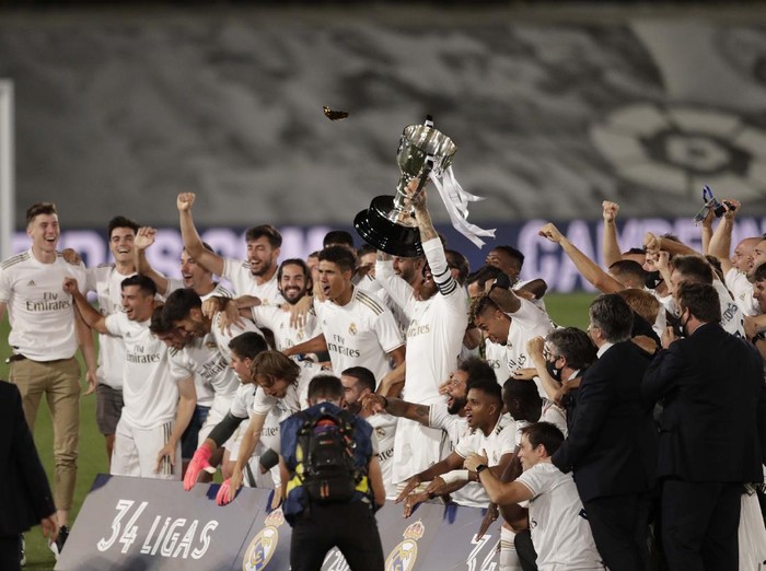 Real Madrid's head coach Zinedine Zidane, holds the trophy as he poses for the photographers after winning the Spanish La Liga 2019-2020 following a soccer match between Real Madrid and Villareal at the Alfredo di Stefano stadium in Madrid, Spain, Thursday, July 16, 2020. (AP Photo/Bernat Armangue)