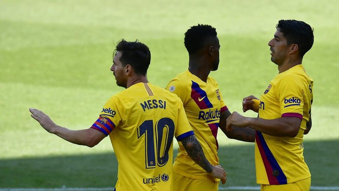 Barcelonas Nelson Semedo, center, celebrates with his teammates Lionel Messi, left, and Luis Suarez, his goal against Alaves during the Spanish La Liga soccer match between Alaves and FC Barcelona, at Mendizorroza stadium, in Vitoria, northern Spain, Sunday, July 19, 2020. (AP Photo/Alvaro Barrientos)