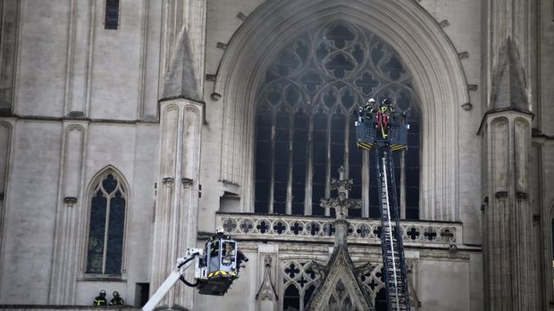 Fire fighters brigade work to extinguish the blaze at the Gothic St. Peter and St. Paul Cathedral, in Nantes, western France, Saturday, July 18, 2020. The fire broke, shattering stained glass windows and sending black smoke spewing from between its two towers of the 15th century, which also suffered a serious fire in 1972. The fire is bringing back memories of the devastating blaze in Notre Dame Cathedral in Paris last year that destroyed its roof and collapsed its spire and threatened to topple the medieval monument. (AP Photo/Romain Boulanger)