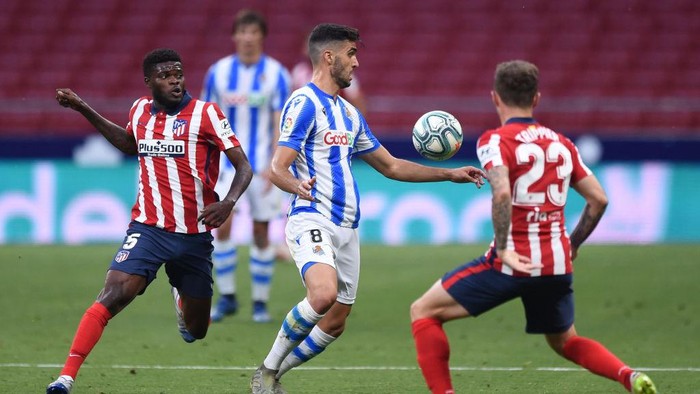 MADRID, SPAIN - JULY 19: Mikel Merino of Real Sociedad is challenged by Thomas Partey and Kieran Trippier of Atletico during the Liga match between Club Atletico de Madrid and Real Sociedad at Wanda Metropolitano on July 19, 2020 in Madrid, Spain. (Photo by Denis Doyle/Getty Images)