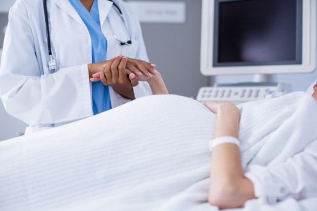 doctor comforting pregant woman during ultrasound scan
