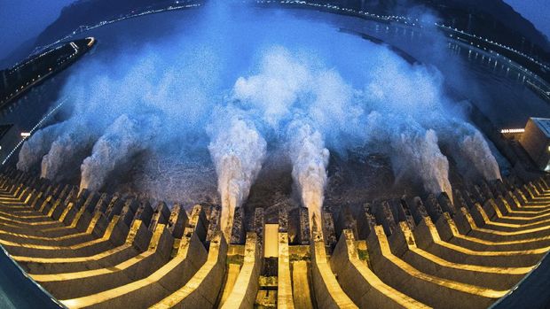 In this image made with fisheye lens and provided by Xinhua News Agency, floodwaters are discharged at the Three Gorges Dam in central China's Hubei province on Sunday, July 19, 2020. Authorities in the neighboring province of Anhui blasted a dam Sunday to release surging waters behind it amid widespread flooding across the country that has claimed scores of lives. (Xiao Yijiu/Xinhua via AP)