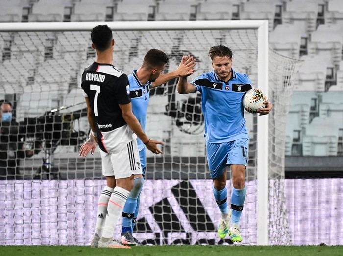 Lazios Italian forward Ciro Immobile (R) celebrates with teammates, next to Juventus Portuguese forward Cristiano Ronaldo reacting, after scoring a goal during the Italian Serie A football match between Juventus and Lazio, on July 20, 2020 at the Allianz stadium, in Turin, northern Italy. (Photo by Marco BERTORELLO / AFP)