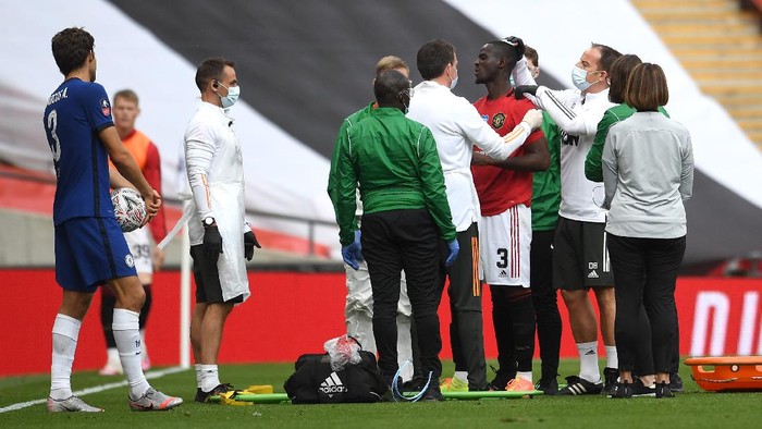 LONDON, ENGLAND - JULY 19: Eric Bailly of Manchester United is seen to by medical staff after a head collision during the FA Cup Semi Final match between Manchester United and Chelsea at Wembley Stadium on July 19, 2020 in London, England. Football Stadiums around Europe remain empty due to the Coronavirus Pandemic as Government social distancing laws prohibit fans inside venues resulting in all fixtures being played behind closed doors. (Photo by Andy Rain/Pool via Getty Images)