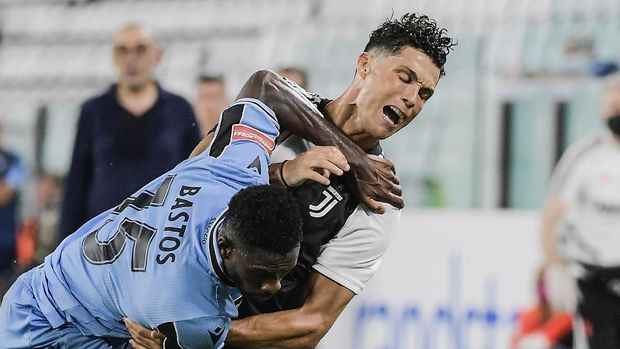 Juventus' Cristiano Ronaldo, right, and Lazio's Bastos compete for the ball during the Italian Serie A soccer match between Juventus and Lazio at the Allianz stadium in Turin, Italy, Monday, July 20, 2020. (Marco Alpozzi/LaPresse via AP)
